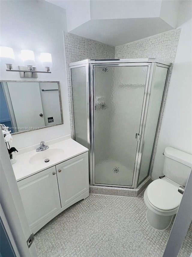 bathroom featuring toilet, vanity, tile patterned floors, and walk in shower