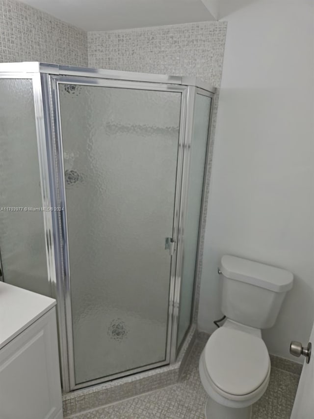 bathroom with tile patterned floors, toilet, and walk in shower