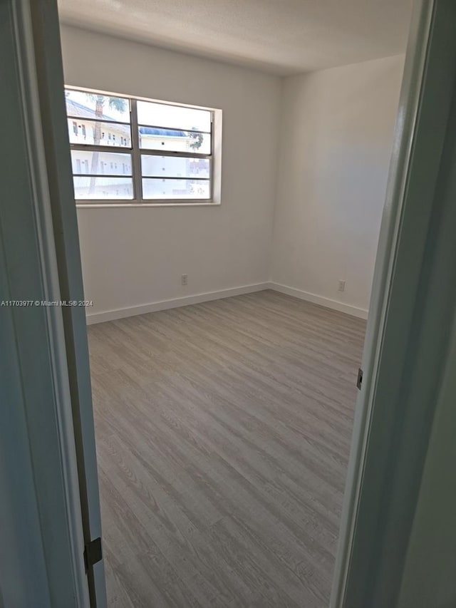 unfurnished room with hardwood / wood-style flooring