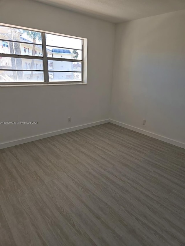 empty room with dark hardwood / wood-style flooring