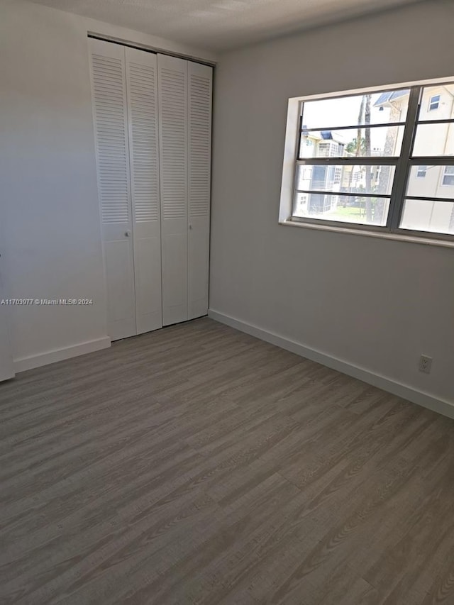 unfurnished bedroom with a closet and dark hardwood / wood-style flooring