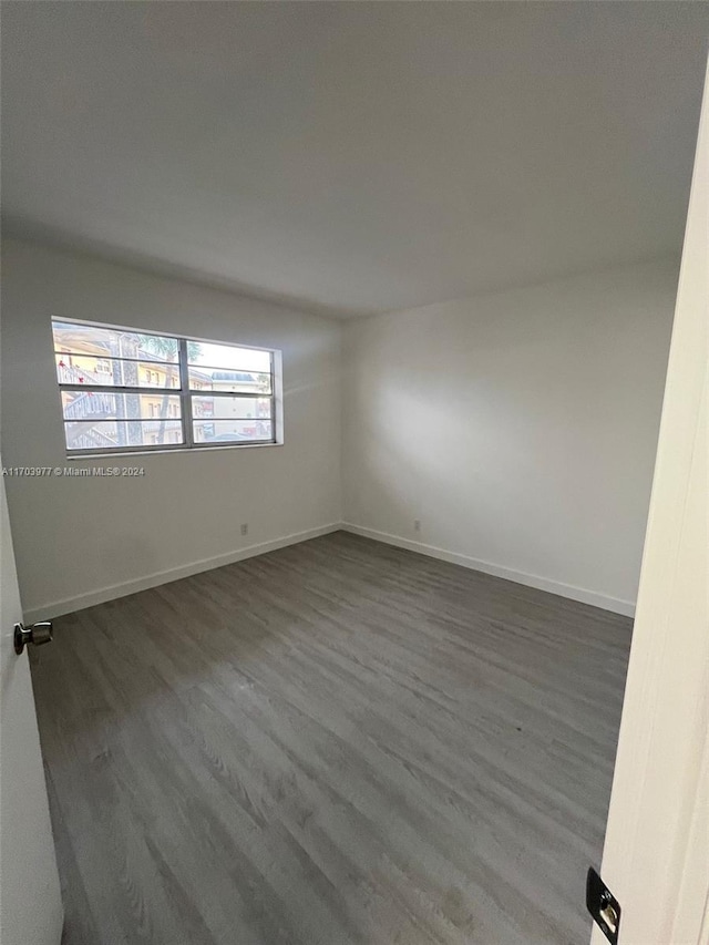 empty room with dark hardwood / wood-style flooring