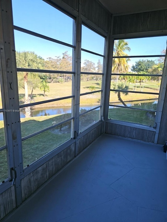 unfurnished sunroom featuring a water view