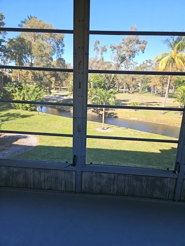 view of gate with a lawn and a water view