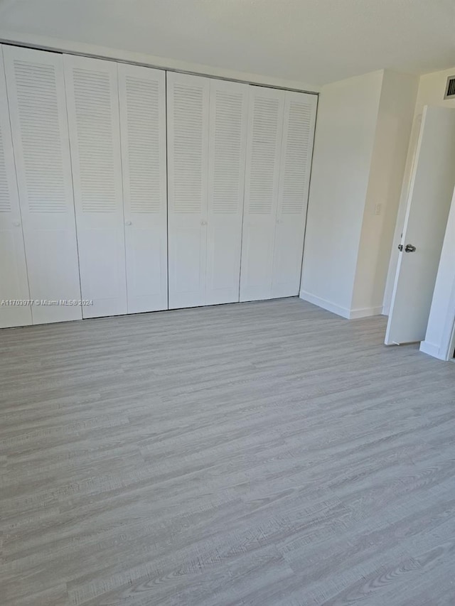 unfurnished bedroom with light hardwood / wood-style floors and a closet