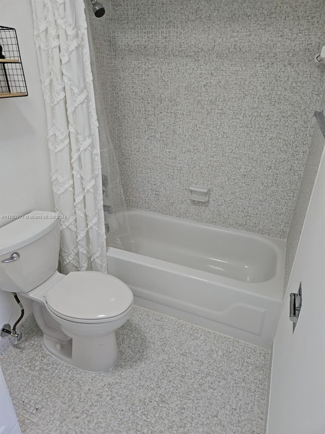 bathroom with toilet and shower / tub combo with curtain