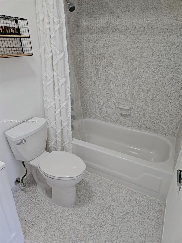 bathroom with shower / tub combo with curtain, tile patterned flooring, and toilet