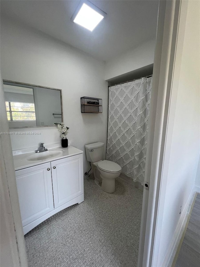 bathroom with a shower with curtain, vanity, and toilet