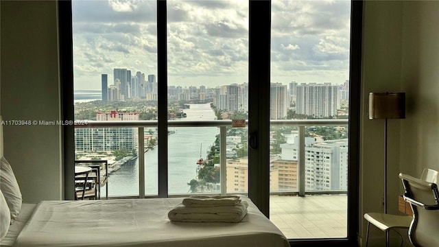 bedroom with a water view and multiple windows