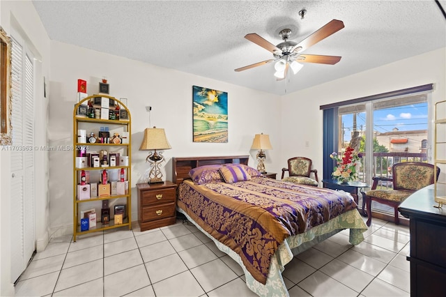 tiled bedroom with ceiling fan and a textured ceiling