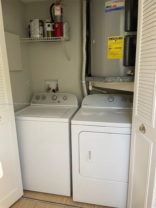clothes washing area with light wood-type flooring and washer and clothes dryer