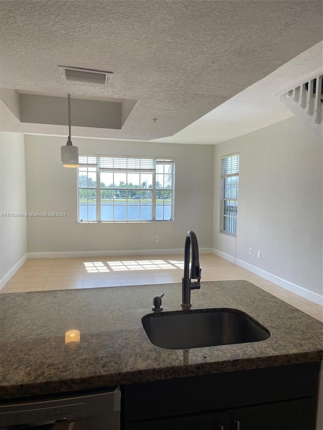 kitchen with pendant lighting, plenty of natural light, sink, and a textured ceiling