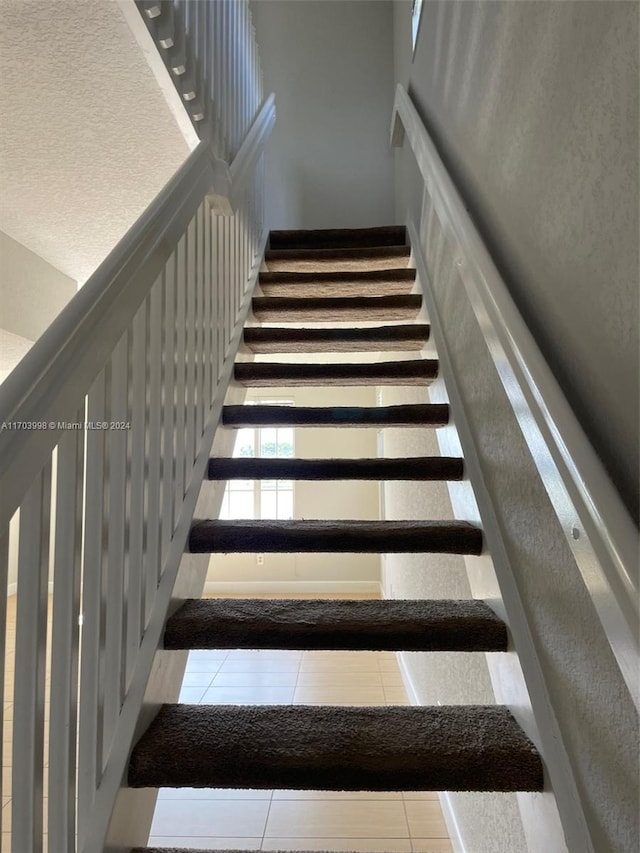 stairway with tile patterned floors
