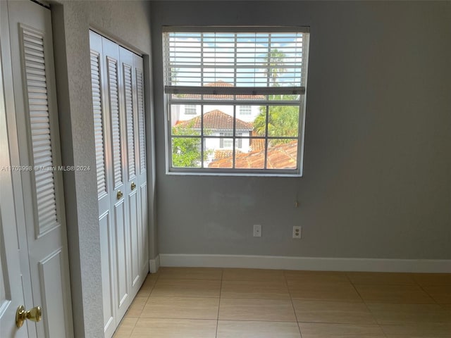 unfurnished bedroom with light tile patterned floors and a closet