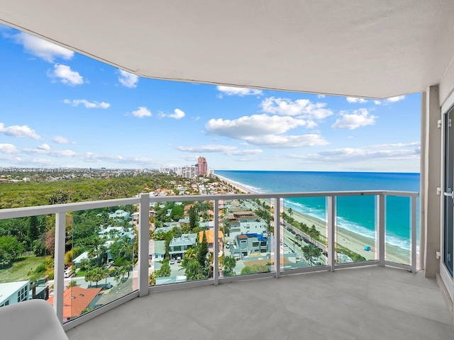 balcony featuring a view of the beach and a water view