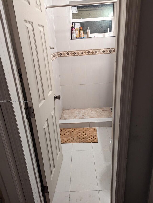 bathroom with a tile shower and tile patterned floors