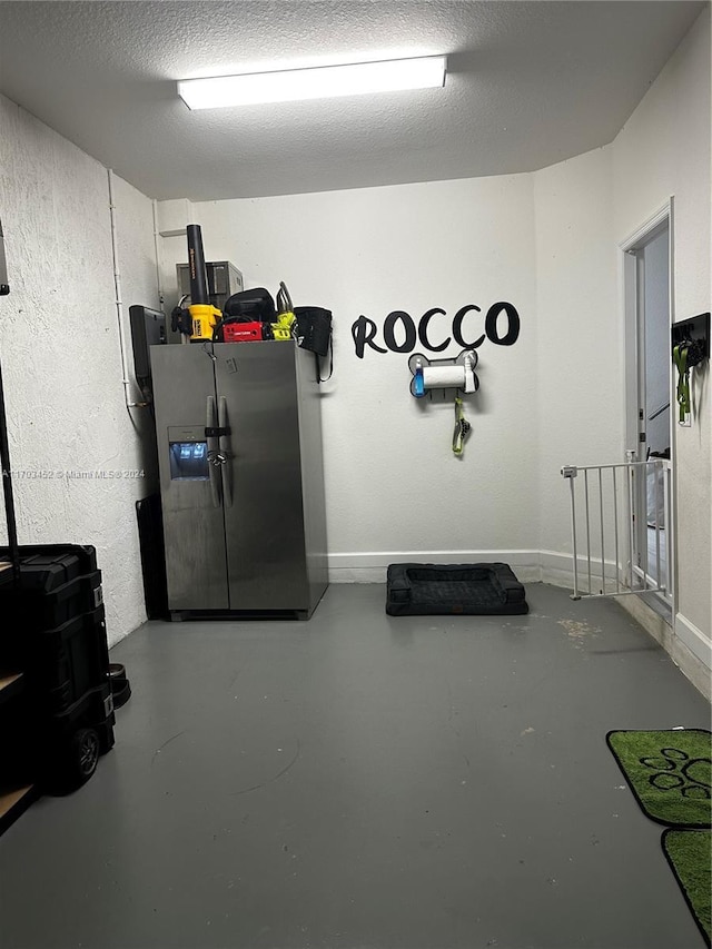 interior space with a textured ceiling and stainless steel refrigerator with ice dispenser