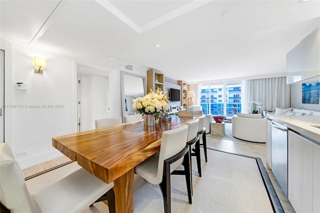 dining space with floor to ceiling windows and light wood-type flooring