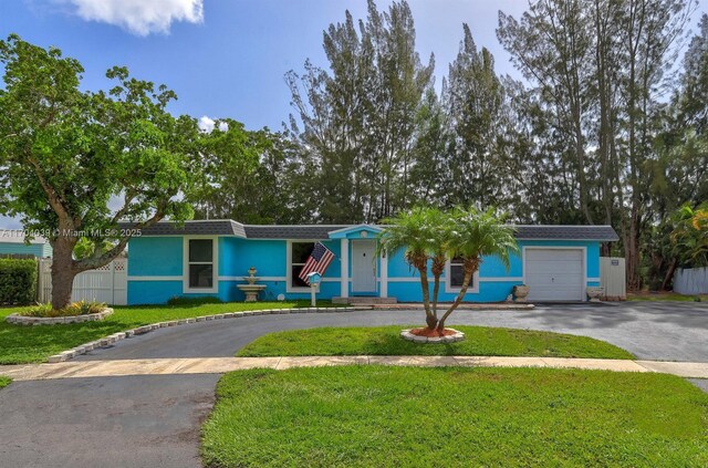 single story home featuring a garage and a front lawn