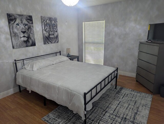 bedroom featuring baseboards and wood finished floors