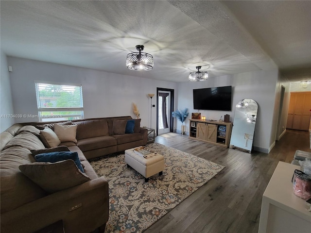 living room featuring a textured ceiling, a chandelier, and dark hardwood / wood-style floors