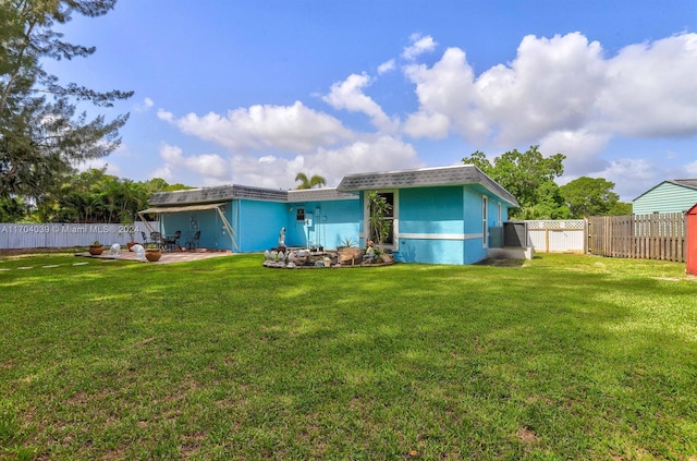 rear view of house with a lawn and a patio area