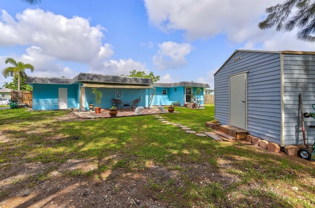 rear view of property with a lawn, a patio area, and a shed