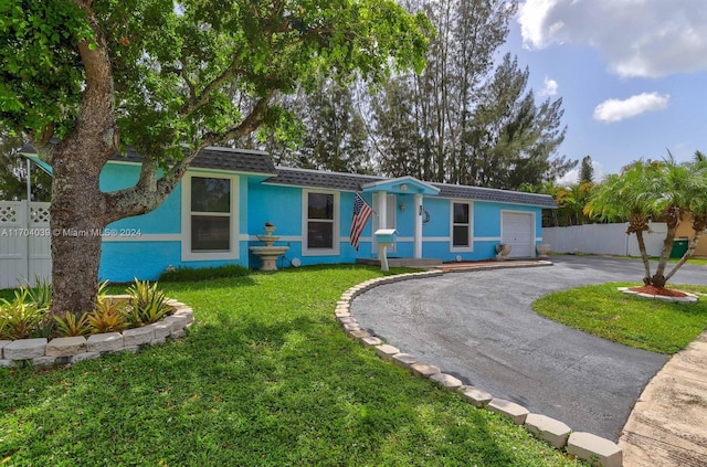 single story home featuring a front lawn and a garage