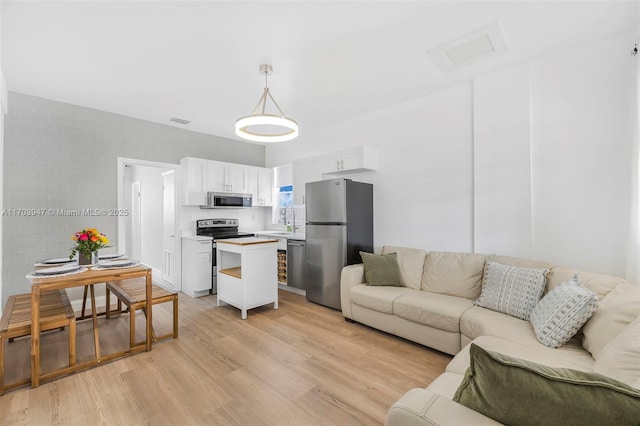 living room with light hardwood / wood-style flooring and sink