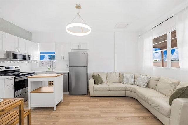 living room featuring light wood-type flooring and sink