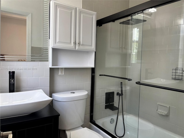 full bathroom with shower / bath combination with glass door, vanity, backsplash, and toilet