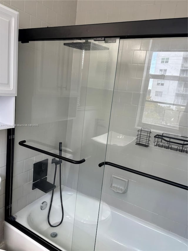 bathroom featuring bath / shower combo with glass door