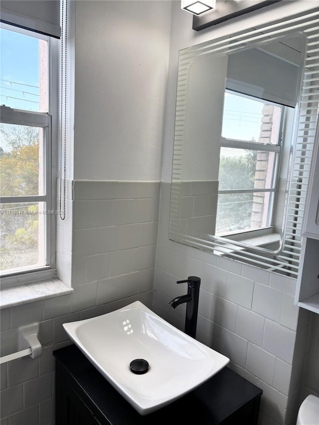 bathroom featuring vanity and tile walls