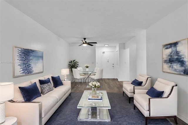 living room featuring dark wood-type flooring and ceiling fan