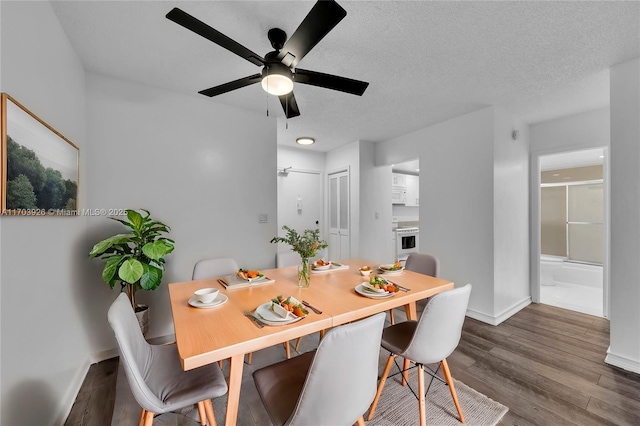 dining space featuring ceiling fan, wood-type flooring, and a textured ceiling