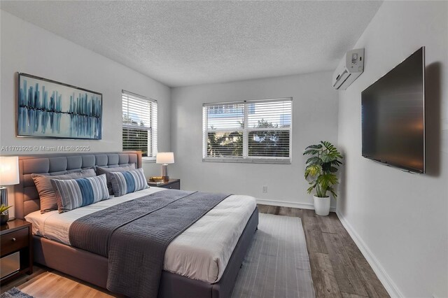 living room featuring hardwood / wood-style floors, a textured ceiling, and a wall unit AC