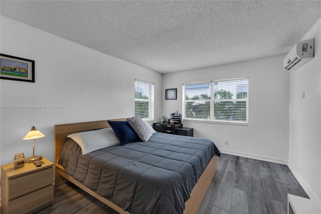 bedroom with an AC wall unit, dark hardwood / wood-style flooring, and a textured ceiling