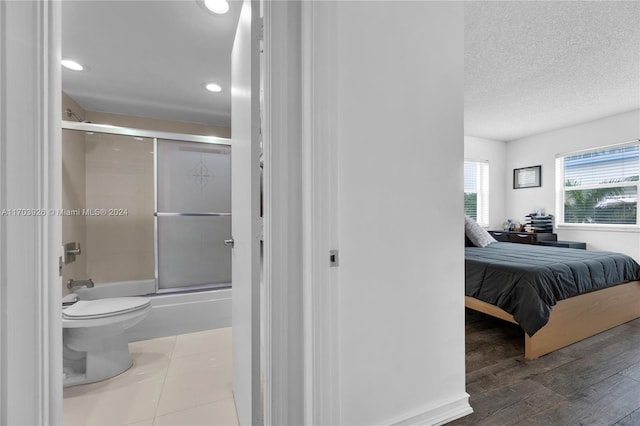 bedroom featuring a textured ceiling and hardwood / wood-style flooring