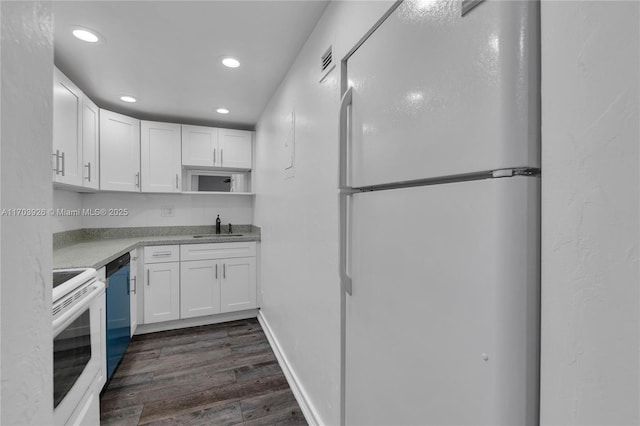 kitchen featuring white cabinetry, dark hardwood / wood-style flooring, sink, and white appliances