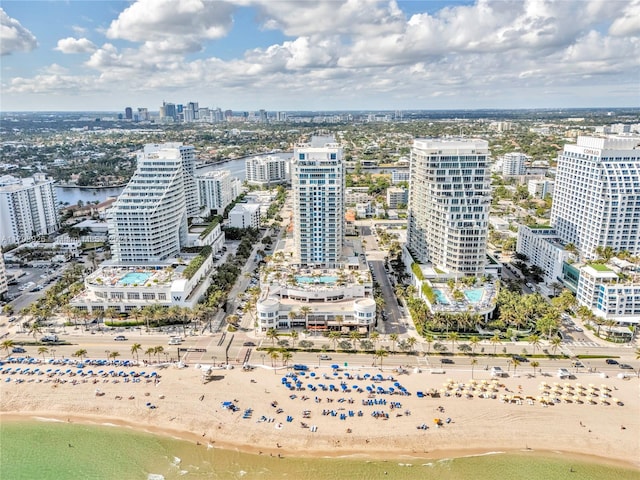 birds eye view of property with a water view and a beach view