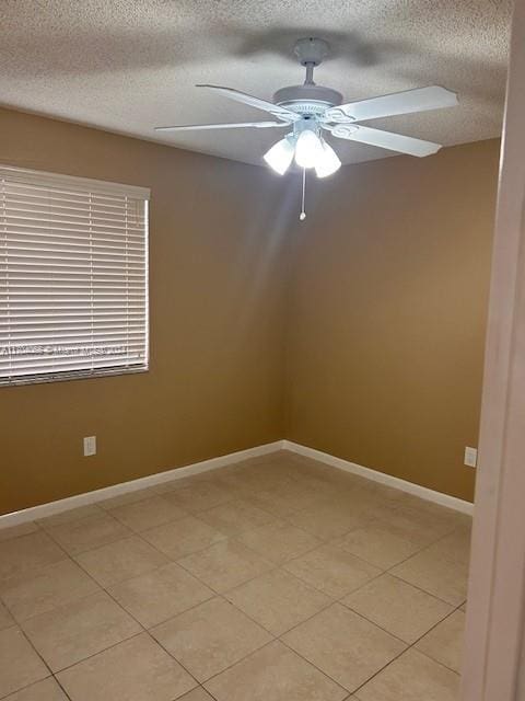 tiled spare room with ceiling fan and a textured ceiling