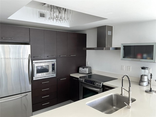 kitchen featuring pendant lighting, exhaust hood, sink, dark brown cabinetry, and stainless steel appliances