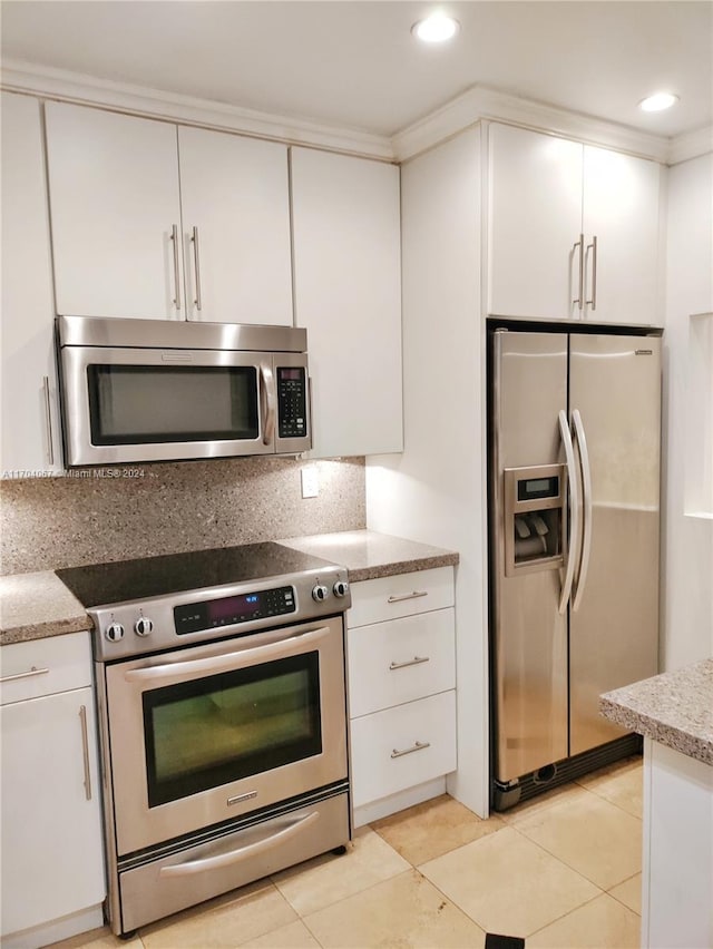 kitchen with light tile patterned flooring, white cabinetry, appliances with stainless steel finishes, and tasteful backsplash