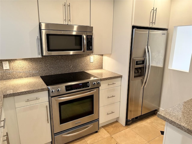 kitchen with white cabinetry, light stone countertops, and appliances with stainless steel finishes