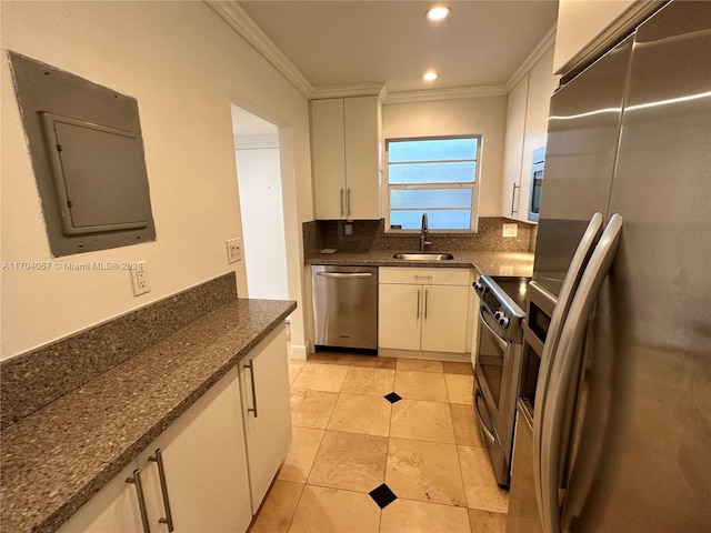 kitchen with backsplash, dark stone counters, white cabinets, sink, and stainless steel appliances