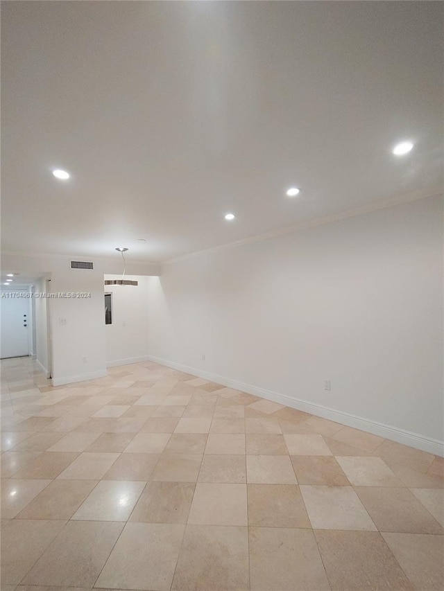 spare room featuring crown molding and light tile patterned flooring