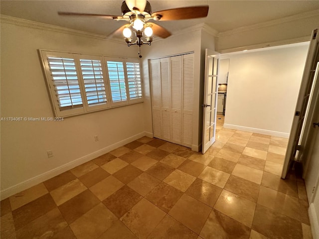 unfurnished bedroom with ceiling fan, a closet, and crown molding