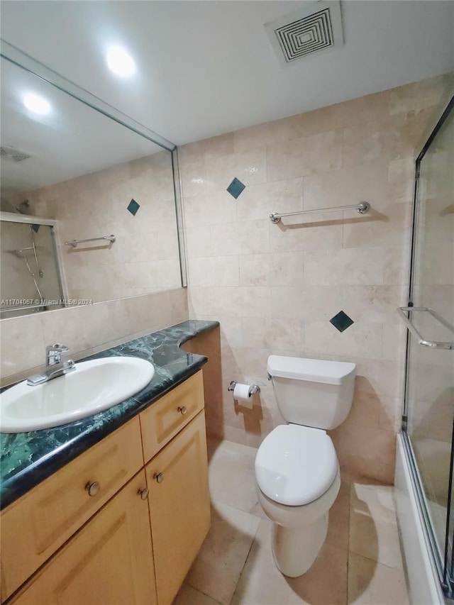 full bathroom featuring tile patterned flooring, vanity, and tile walls