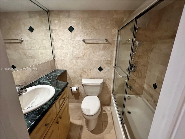 full bathroom featuring tile patterned flooring, enclosed tub / shower combo, toilet, vanity, and tile walls