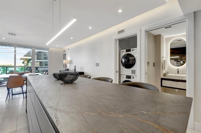 dining room with expansive windows and stacked washer / drying machine